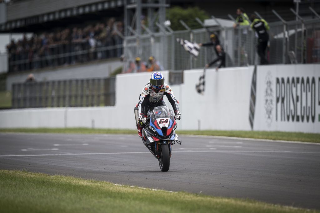 Pebalap tim Rokit BMW Motorrad WorldSBK, Toprak Razgatlioglu, melakukan stoppie saat merayakan kemenangan balapan 2 Superbike seri Inggris di Sirkuit Donington Park, Sabtu (13/7/2024). Razgatlioglu kini memuncaki klasemen dengan 241 poin.