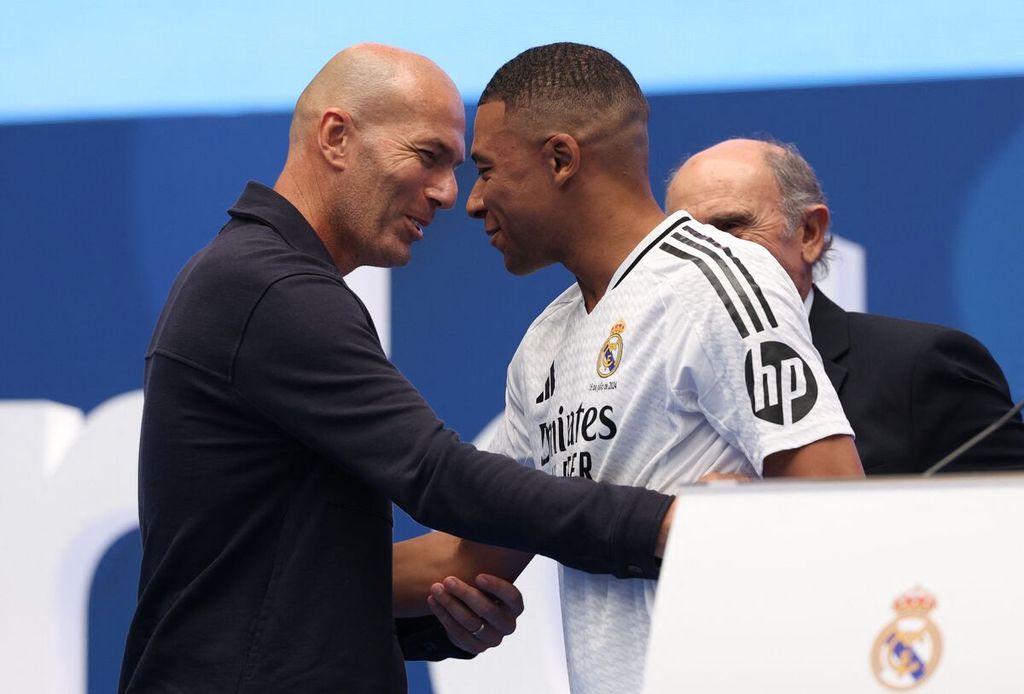 Kylian Mbappe (kanan) disambut mantan pemain Real Madrid, Zinedine Zidane, saat acara perkenalan Mbappe sebagai pemain Real Madrid di Santiago Bernabeu, Madrid, Selasa (16/7/2024).