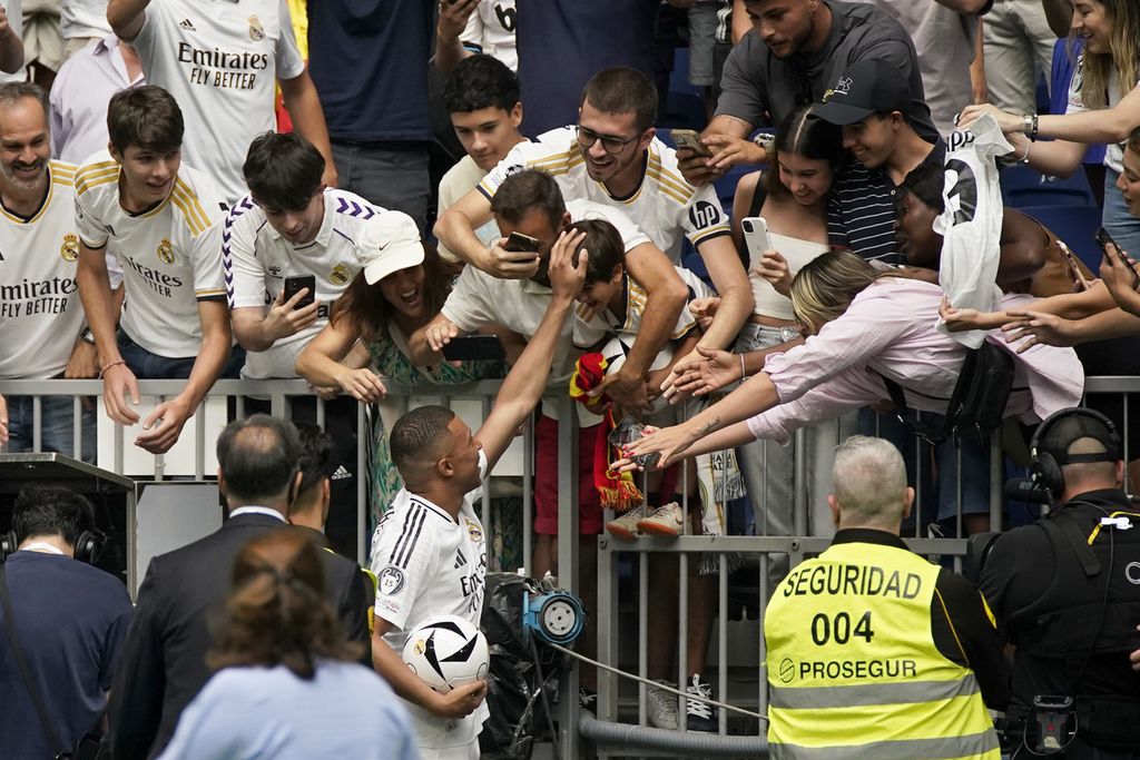 Kylian Mbappe menyambut para suporter saat acara perkenalan dirinya di Stadion Santiago Bernabeu, Madrid, Selasa (16/7/2024).