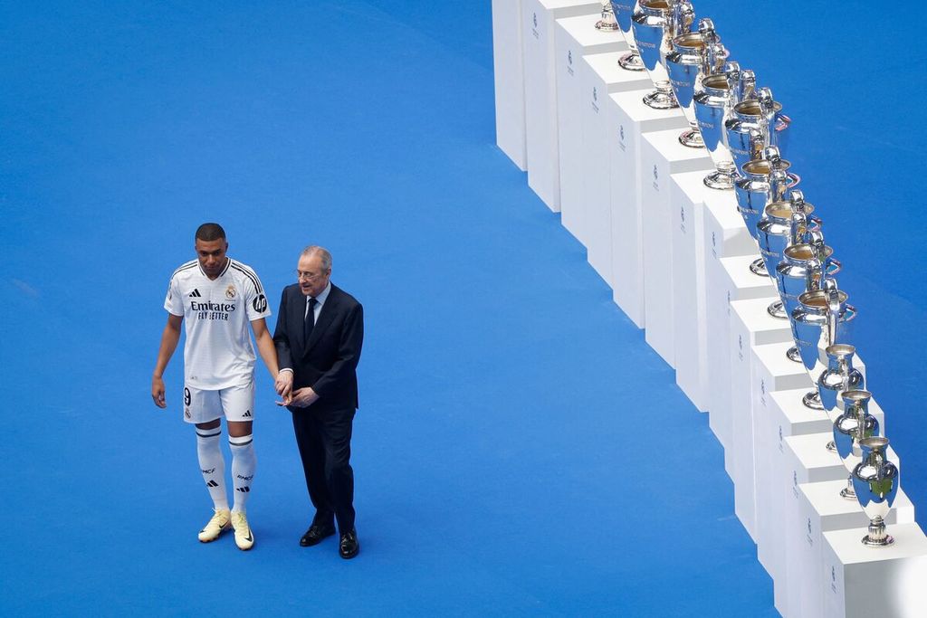 Kylian Mbappe (kiri) berpose dengan Presiden Real Madrid Florentino Perez saat acara perkenalan di Stadion Santiago Bernabeu, Madrid, Selasa (16/7/2024). 