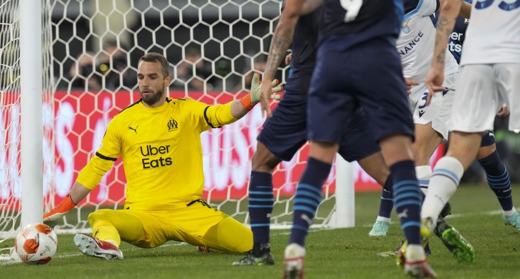 Kiper Marseille Pau Lopez (kiri) berhasil mengamankan bola tendangan pemain Lazio dalam pertandingan grup E Liga Europa di Stadion Olimpico, Roma, Italia, Jumat (22/10/2021) dini hari WIB. Statistik menunjukkan Marseille melakukan 10 kali percobaan tendangan ke gawang, namun hanya satu yang tepat sasaran. 